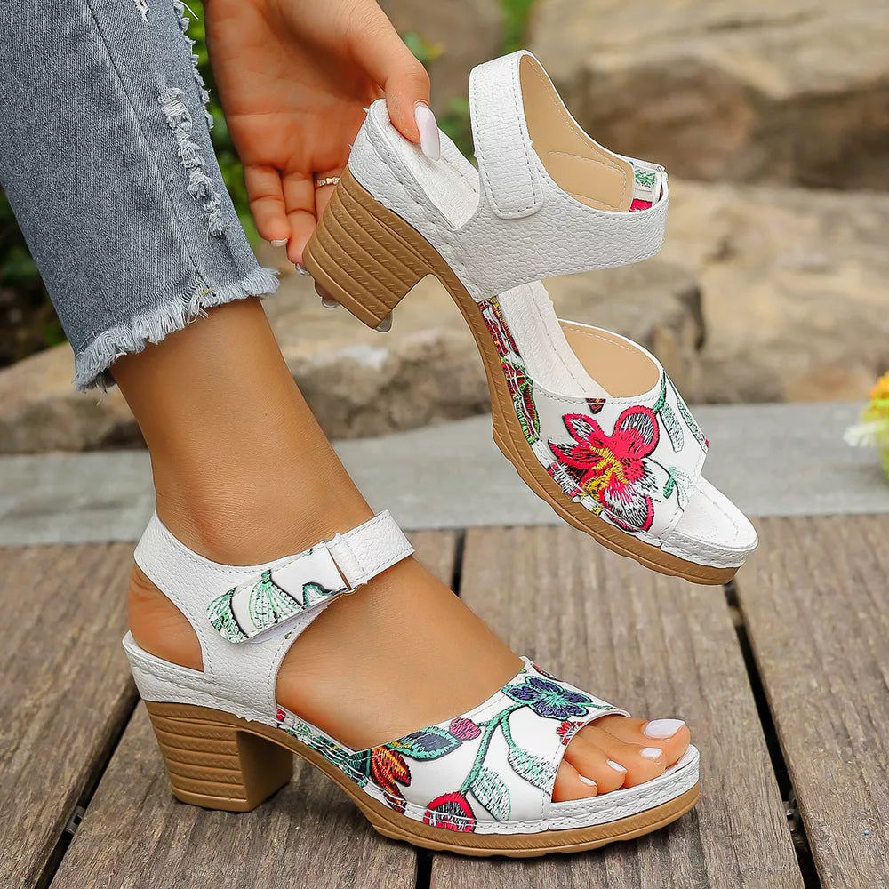 White floral open-toe block heel sandals with adjustable strap.