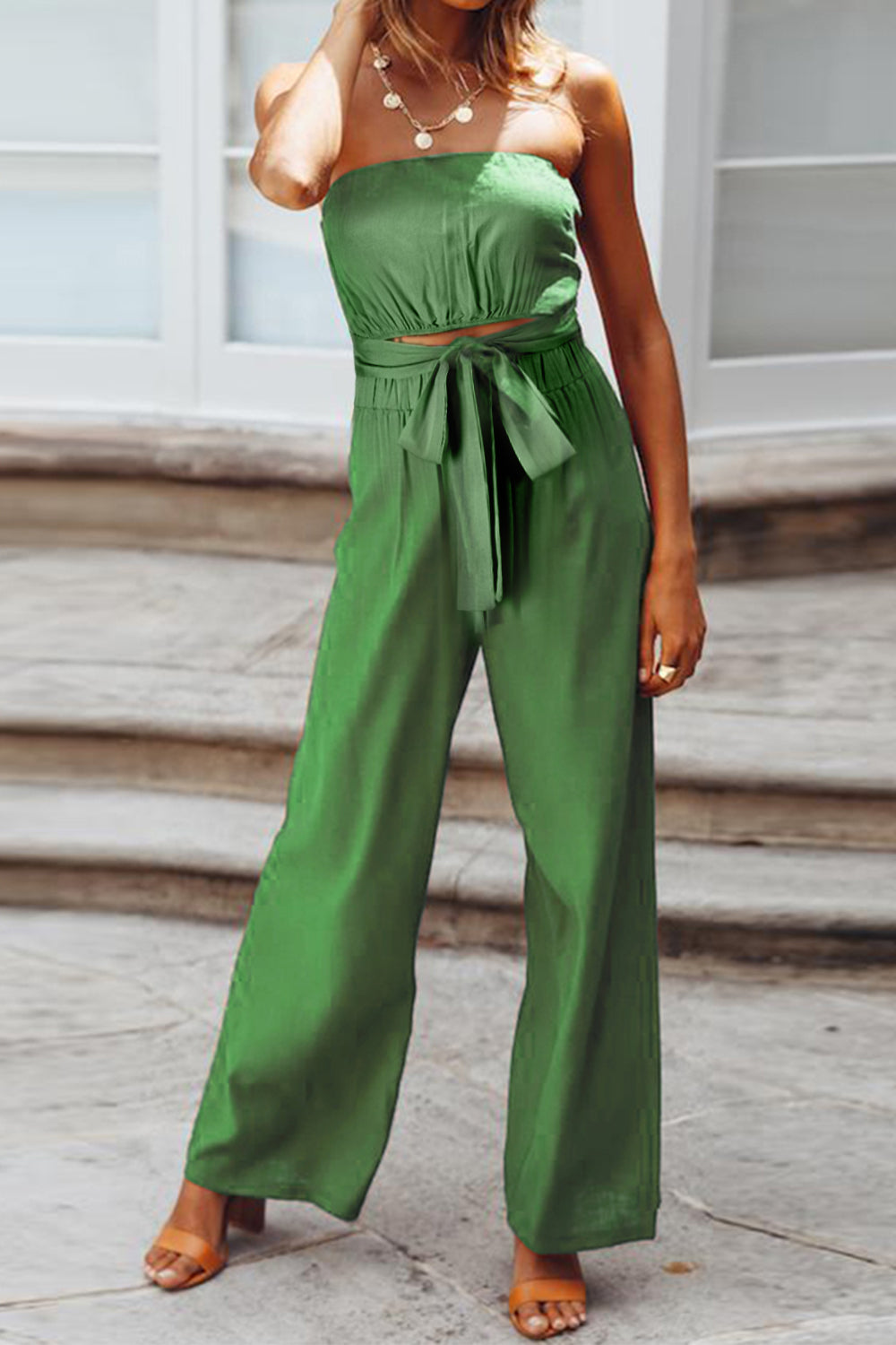 Green bandeau tie-waist wide-leg jumpsuit with a cropped top and flowing pants.
