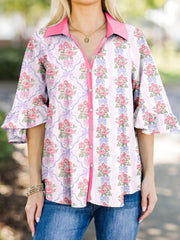 Maternity button-up shirt with pink floral and bow pattern, ruffled sleeves, and pink collar.