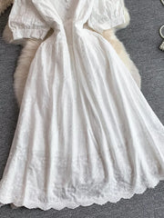 White lace-embellished midi dress with puff sleeves and button detail.