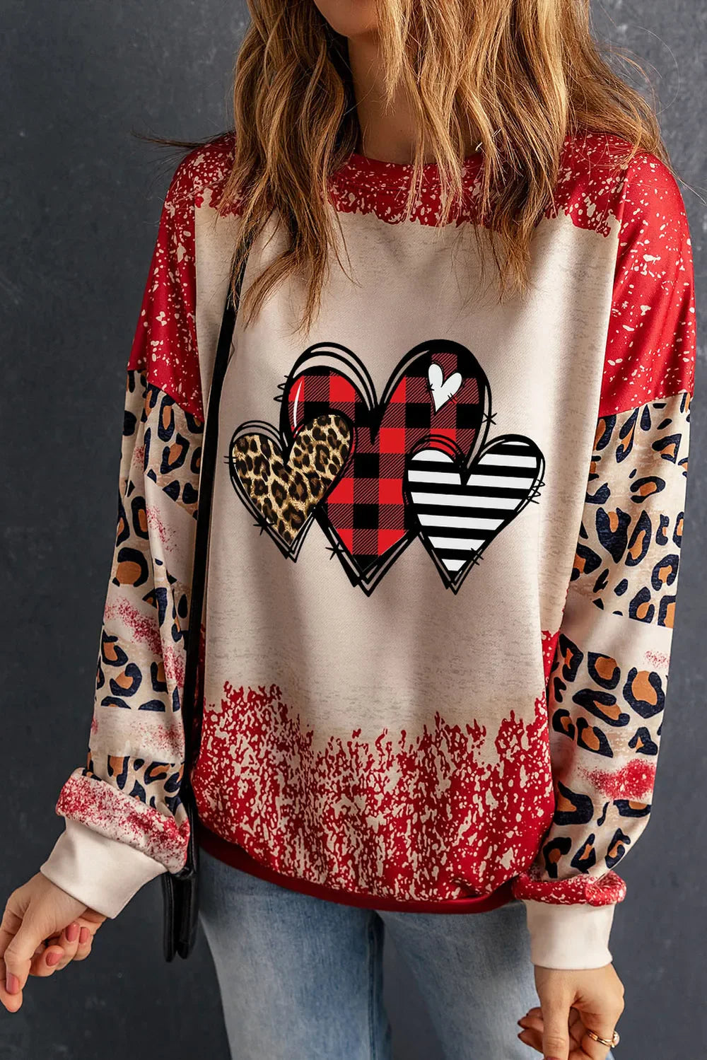 Patchwork sweatshirt with heart graphic, buffalo plaid, leopard print, and stripes.