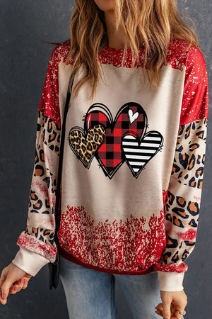 Patchwork sweatshirt with heart graphic, buffalo plaid, leopard print, and stripes.