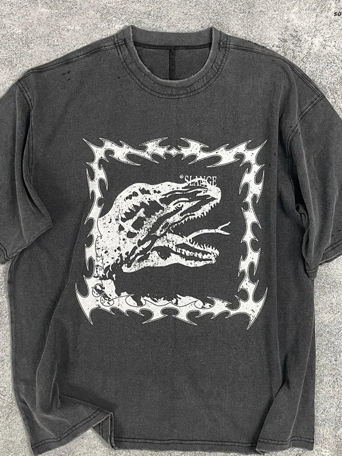 Black distressed graphic tee with white dinosaur motif and tribal border.