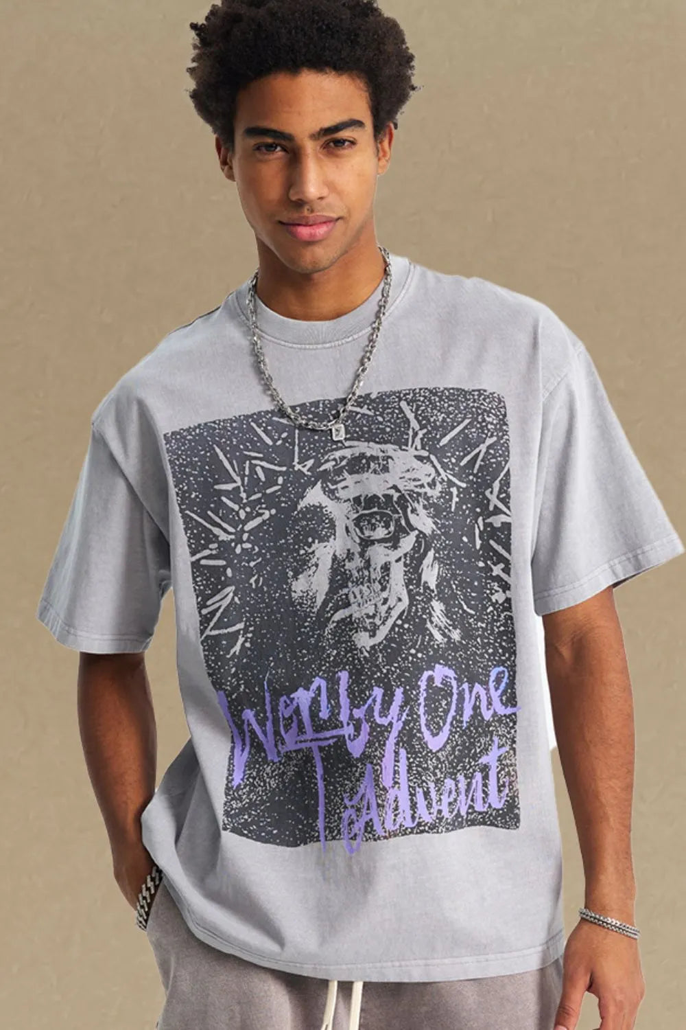 Gray oversized t-shirt with a graphic skull print and purple text that reads "Worn by One Advent".
