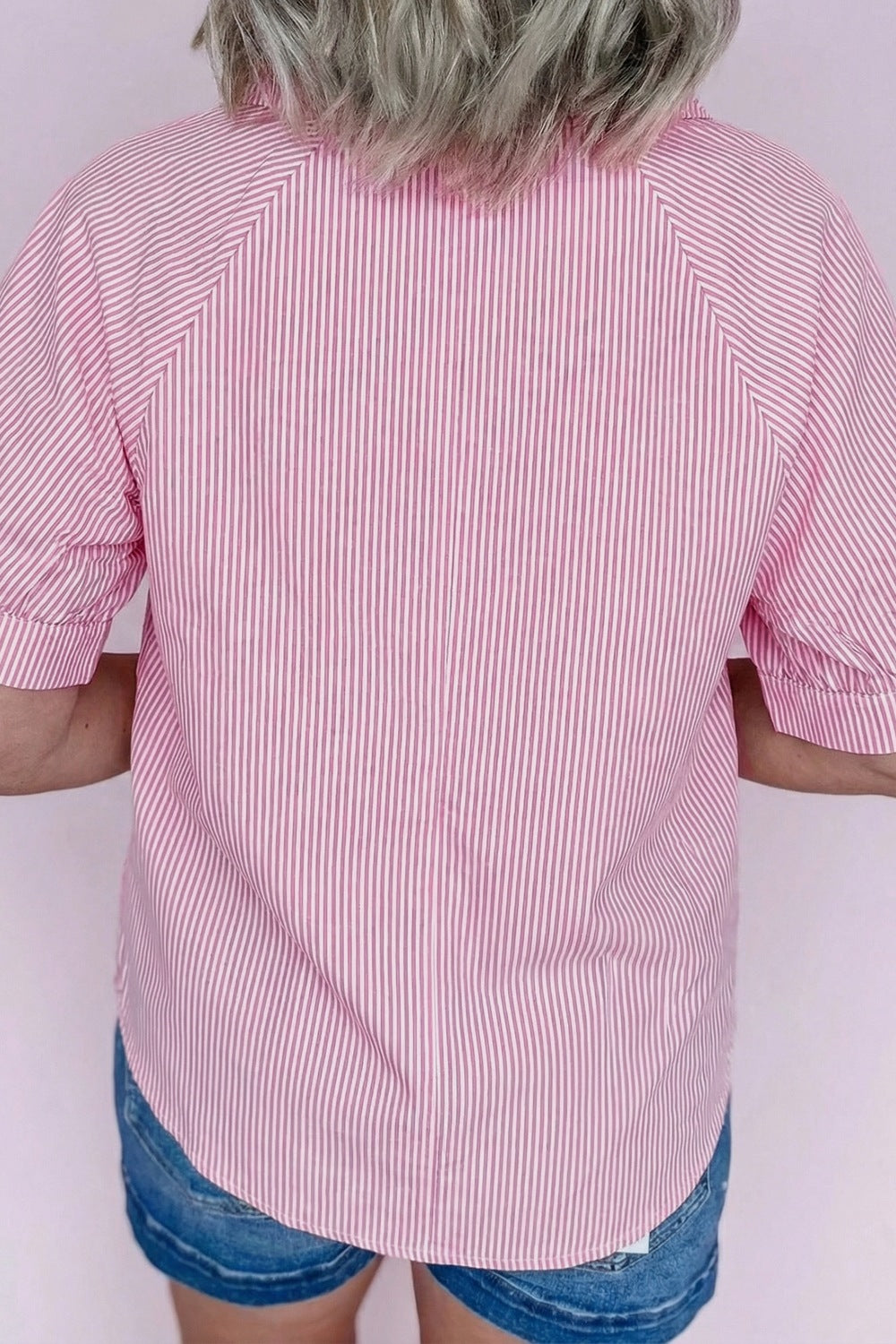 Pink and white striped collared v-neck blouse with short sleeves.
