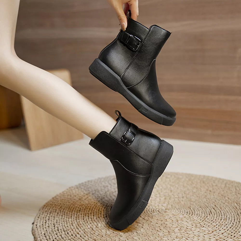 Black round toe ankle boots with decorative buckle detail.